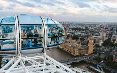 Guests inside a London Eye capsule with views of Big Ben and the Thames below.