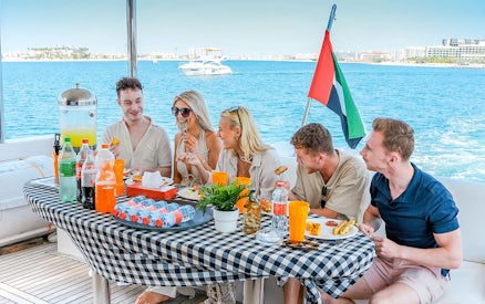 Guests enjoying breakfast on a luxury yacht cruise with ocean view.
