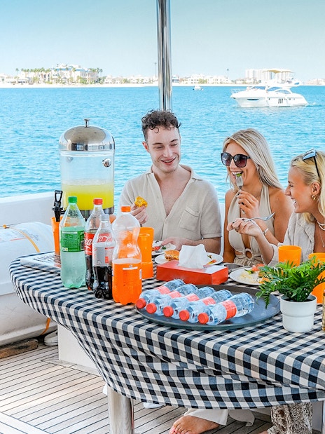 Guests enjoying breakfast on a luxury yacht cruise with ocean view.