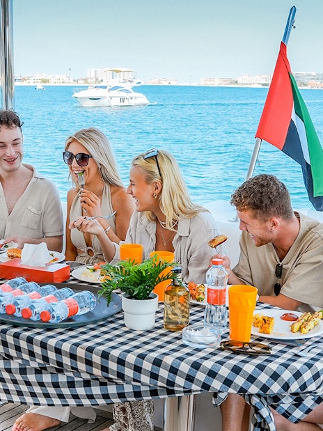 Guests enjoying breakfast on a luxury yacht cruise with ocean view.