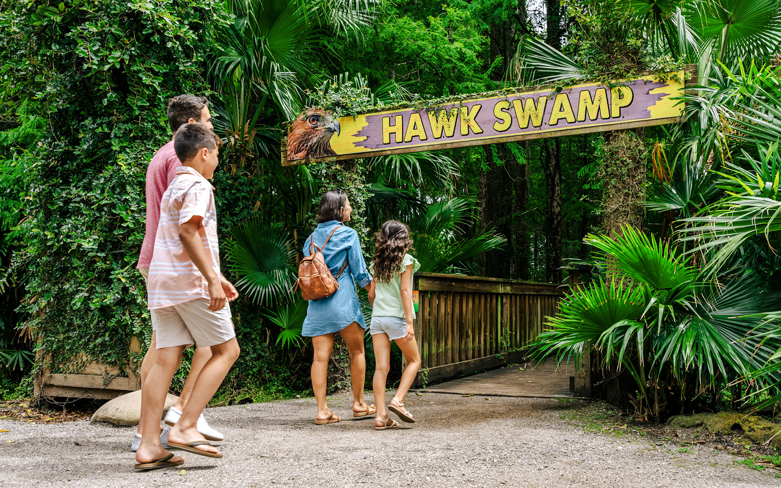Family walking towards Hawk Swamp entrance at Gator Park, Orlando.