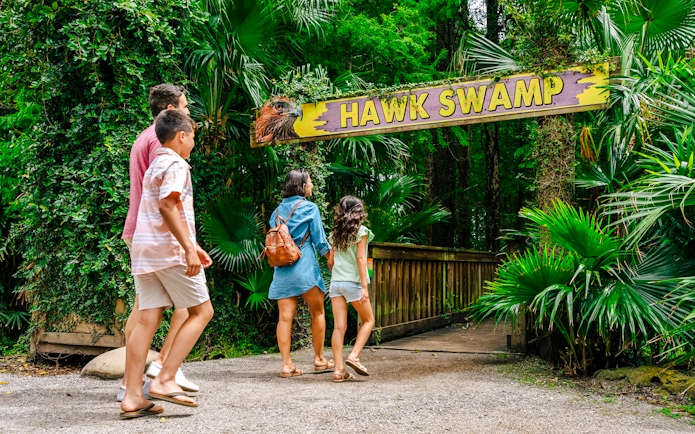 Family walking towards Hawk Swamp entrance at Gator Park, Orlando.