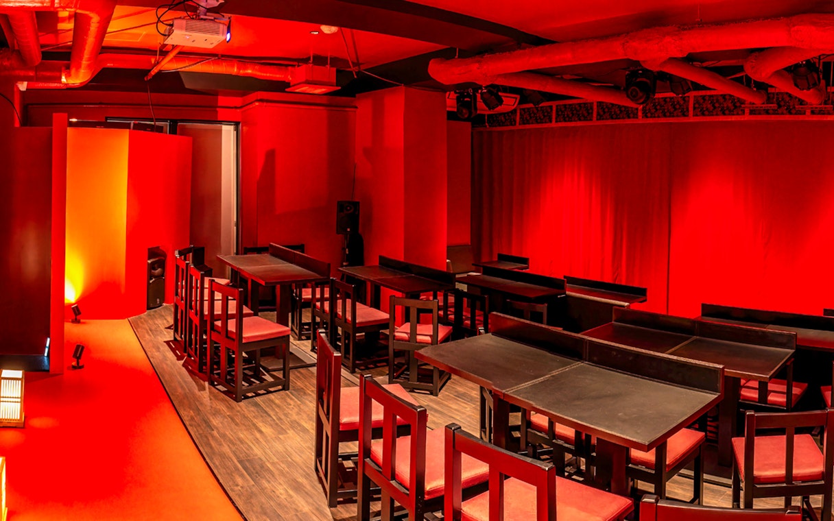 Japanese cabaret theatre interior with red decor and seating in Tokyo.