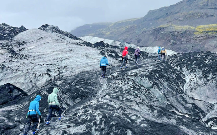 Guests hiking on Sólheimajökull Glacier in Iceland during a small group tour.