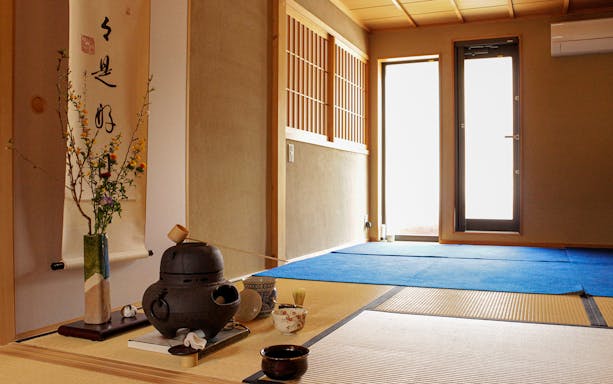 Teahouse interior with tatami mats and tea ceremony setup in Kyoto.
