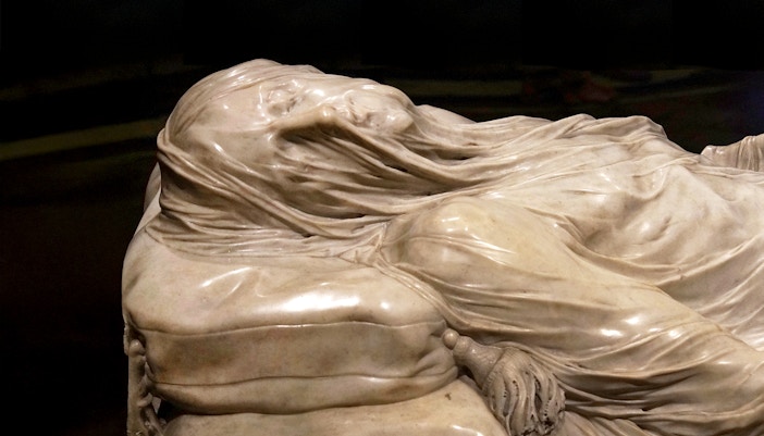 Veiled Christ sculpture in Naples' Sansevero Chapel, showcasing intricate marble craftsmanship.