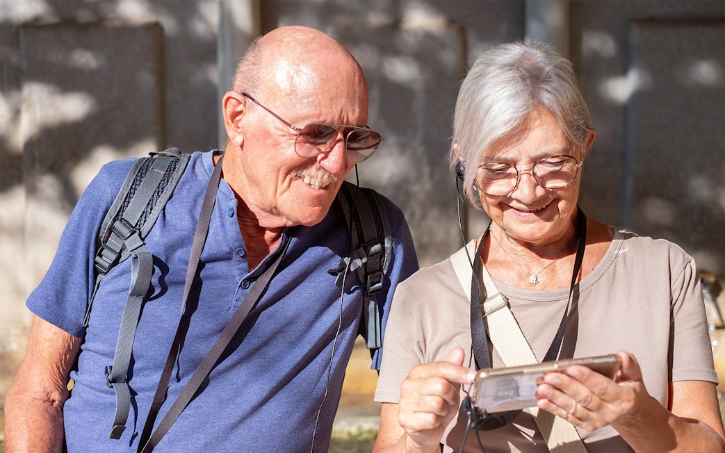 Tourists using audio guide in Paris's Latin Quarter with OPA SI Pass.