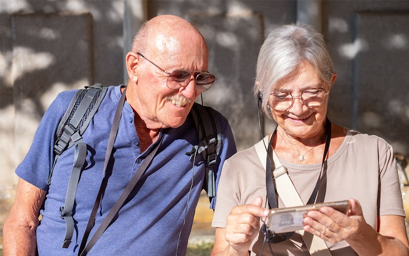 Tourists using audio guide in Paris's Latin Quarter with OPA SI Pass.