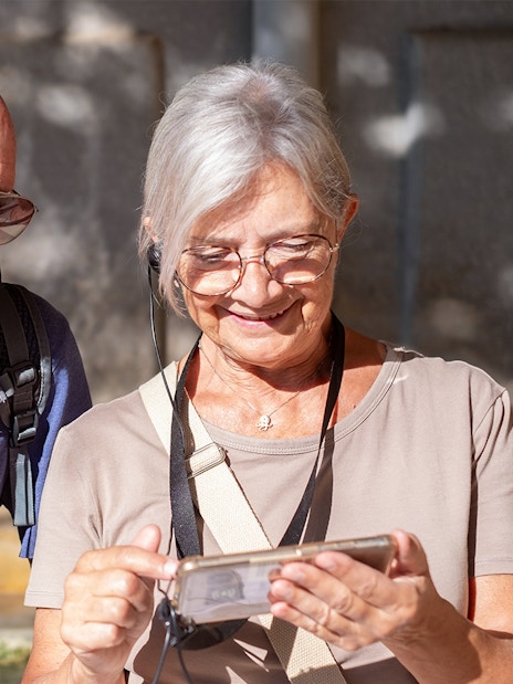 Tourists using audio guide in Paris's Latin Quarter with OPA SI Pass.