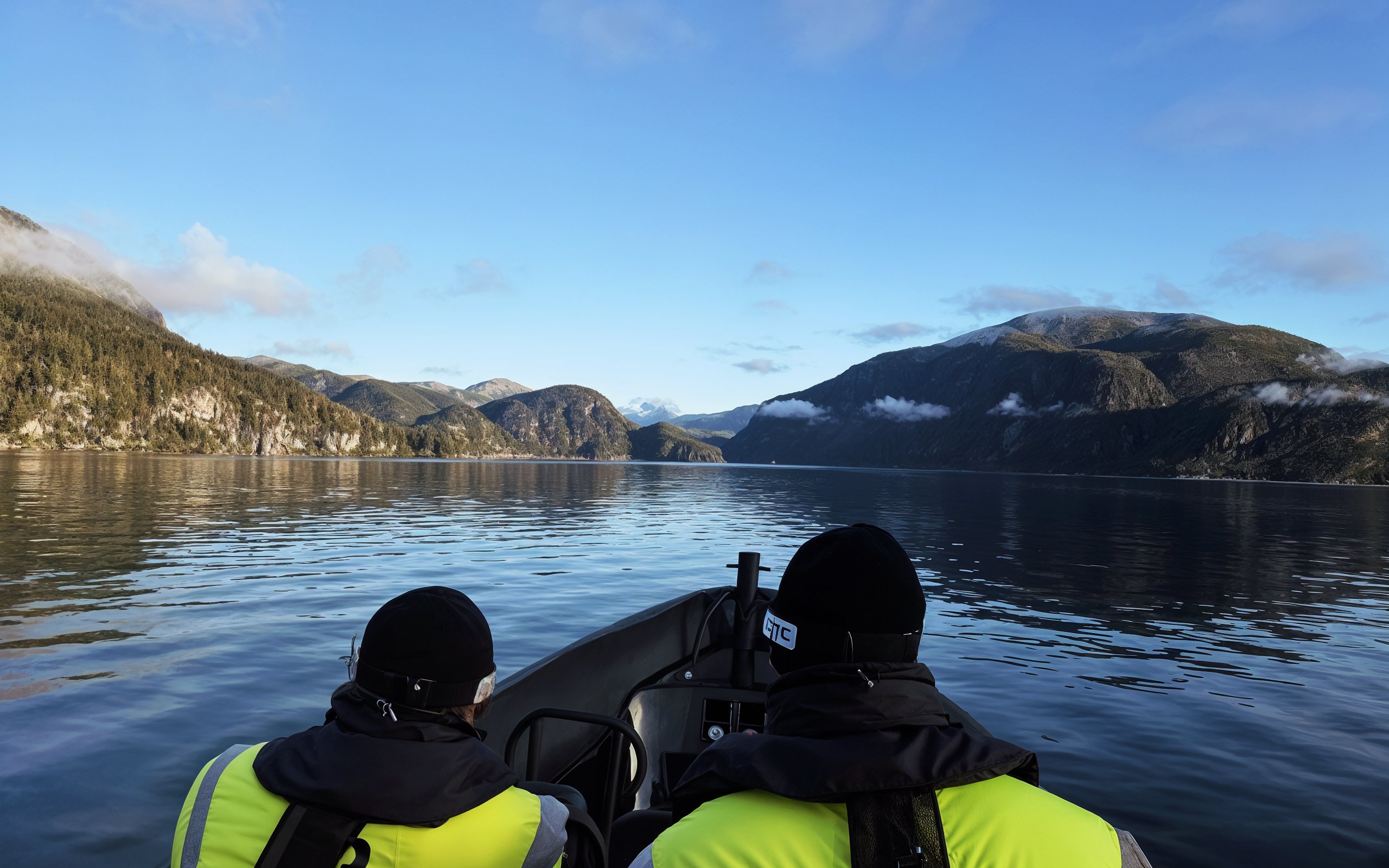 Boat tour through Mostraumen channel with scenic mountain views.