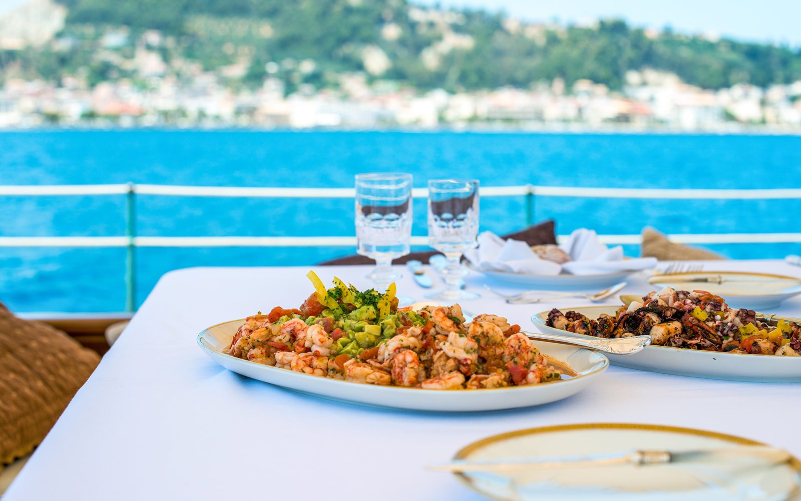 Seafood lunch on a cruise ship with view of Agistri and Aegina islands in the background.
