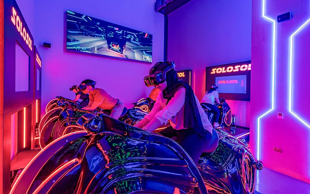 Visitors enjoying virtual reality motorbike experience at Al Qana, Abu Dhabi.