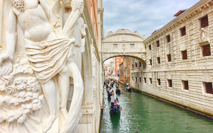 Gondola ride near Bridge of Sighs on a canal in Venice, Italy.