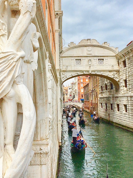 Gondola ride near Bridge of Sighs on a canal in Venice, Italy.