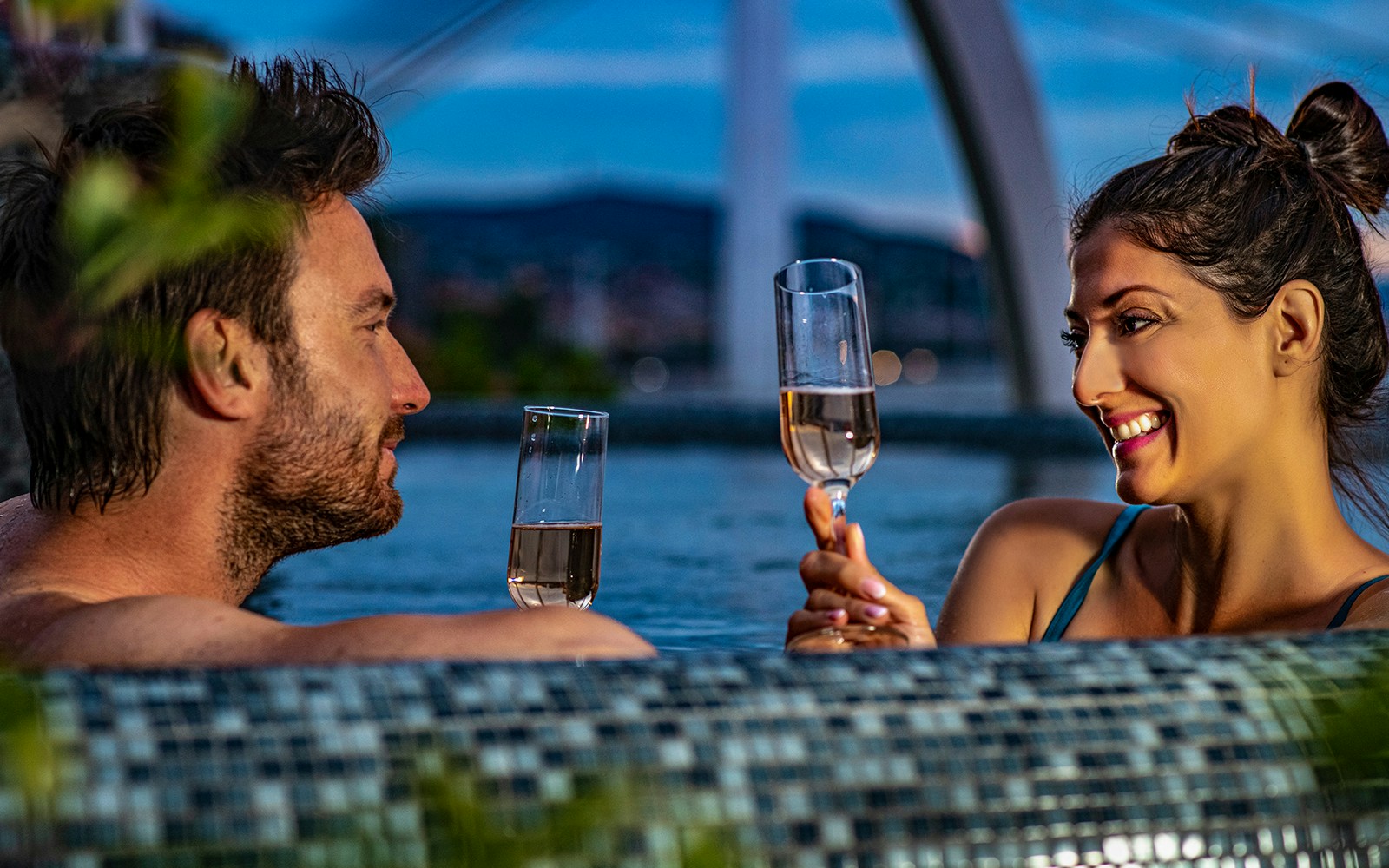 Couple enjoying champagne at Rudas Bath during New Year's Eve party in Budapest.
