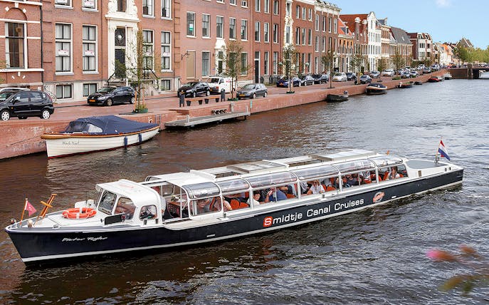 Canal cruise boat on Alkmaar's scenic waterways with historic buildings in the background.