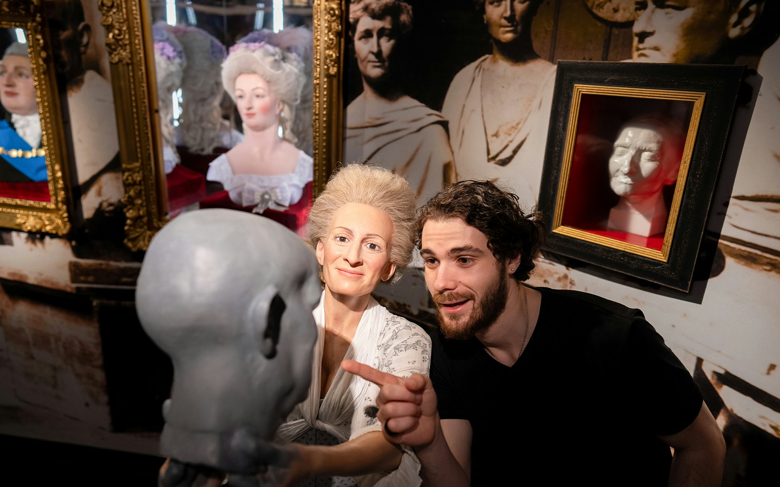 Man observing wax figure creation process at Madame Tussauds, New York.