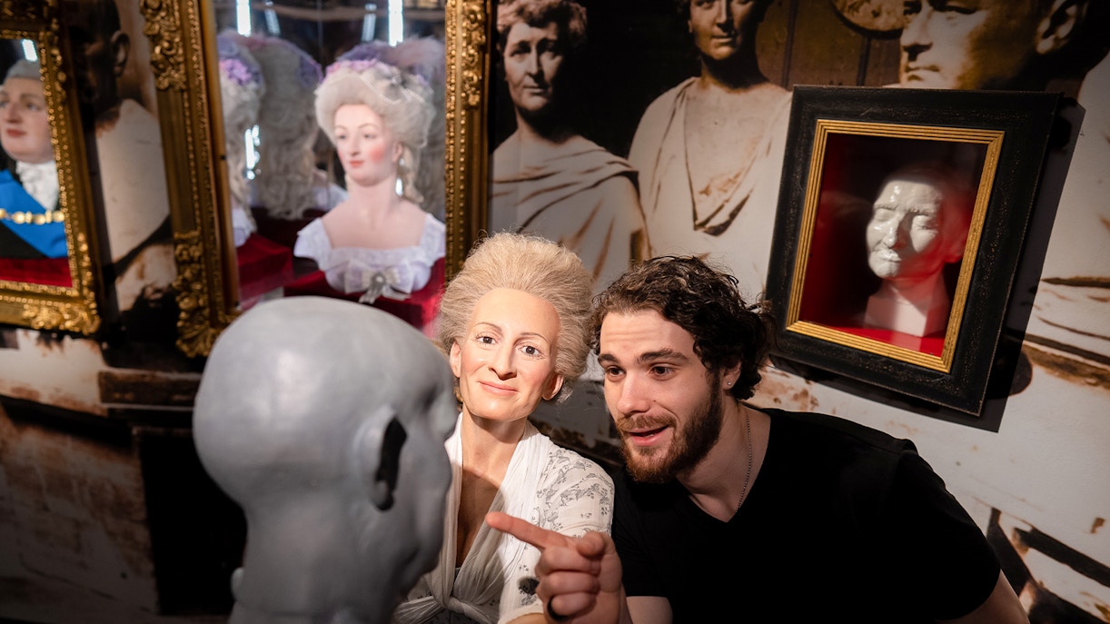 Man observing wax figure creation process at Madame Tussauds, New York.