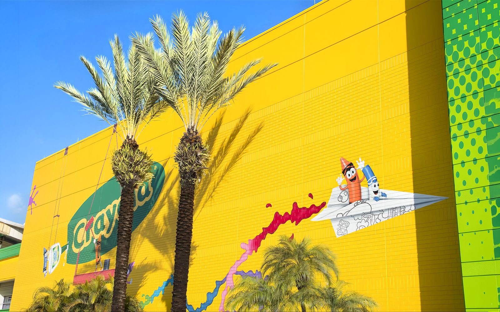 Crayola Experience Orlando exterior with colorful mural and palm trees.