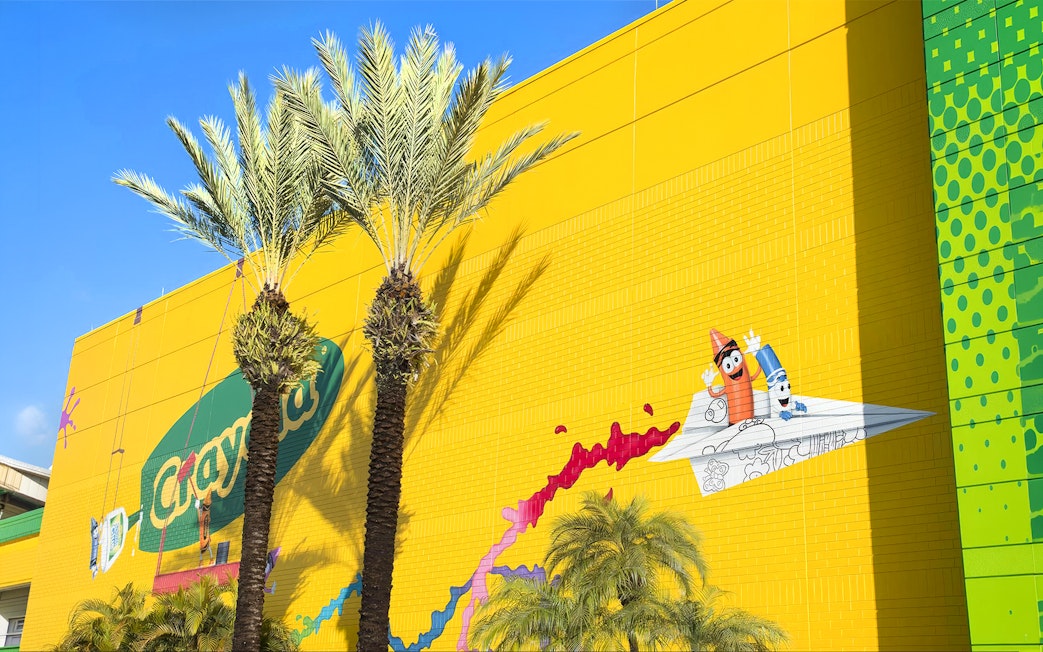Crayola Experience Orlando exterior with colorful mural and palm trees.