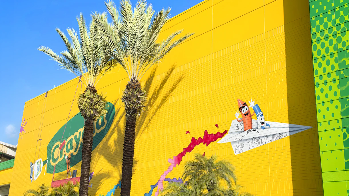 Crayola Experience Orlando exterior with colorful mural and palm trees.