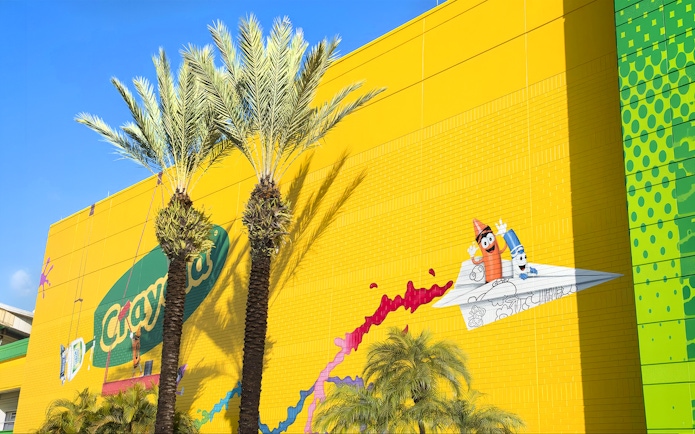 Crayola Experience Orlando exterior with colorful mural and palm trees.