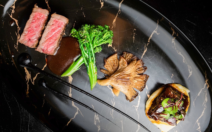 Lunch set menu with steak, broccolini, mushrooms, and sauce at CÉ LA VI Dubai.