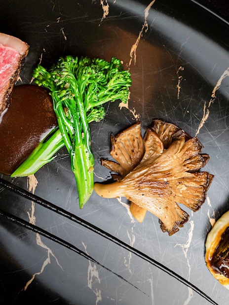 Lunch set menu with steak, broccolini, mushrooms, and sauce at CÉ LA VI Dubai.