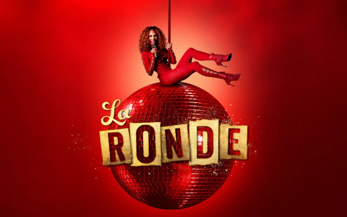 Performer in red outfit on a red disco ball with "La Ronde" text, Sydney.