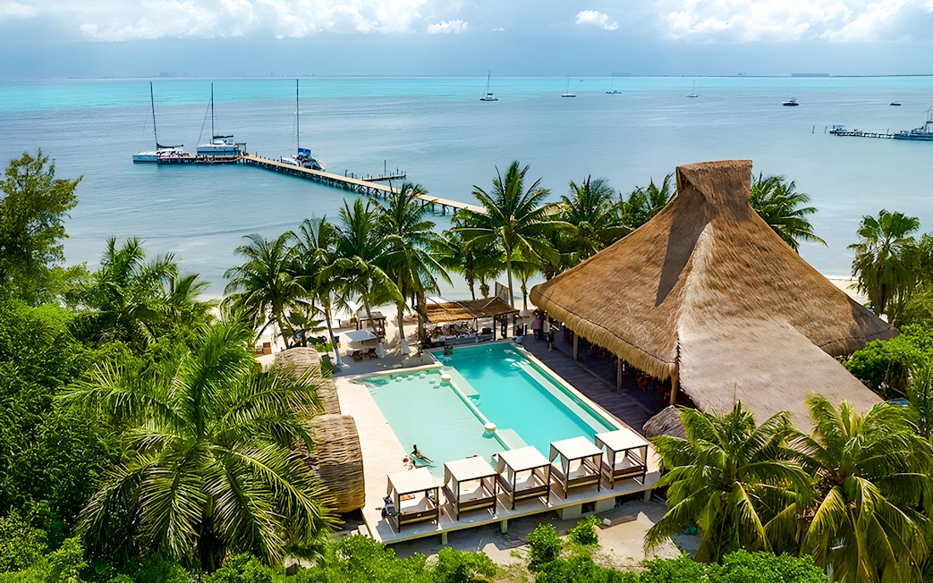 Zaza Beach Club on Isla Mujeres, Mexico with pool, palm trees, and ocean view.