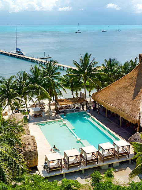 Zaza Beach Club on Isla Mujeres, Mexico with pool, palm trees, and ocean view.