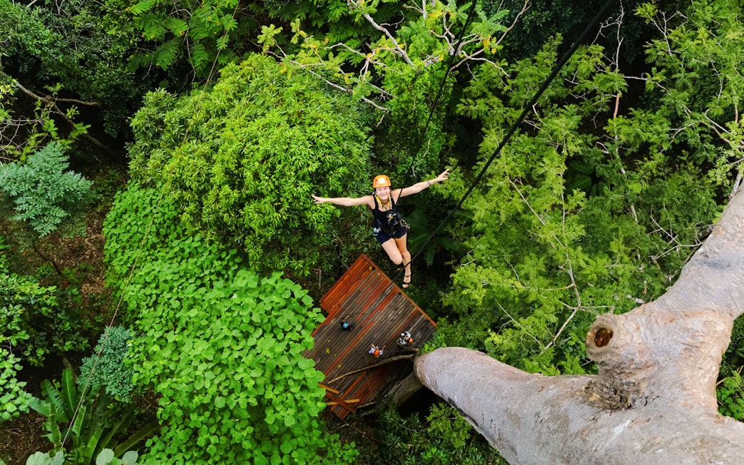 Person ziplining through lush forest canopy at Flying Hanuman, Phuket.