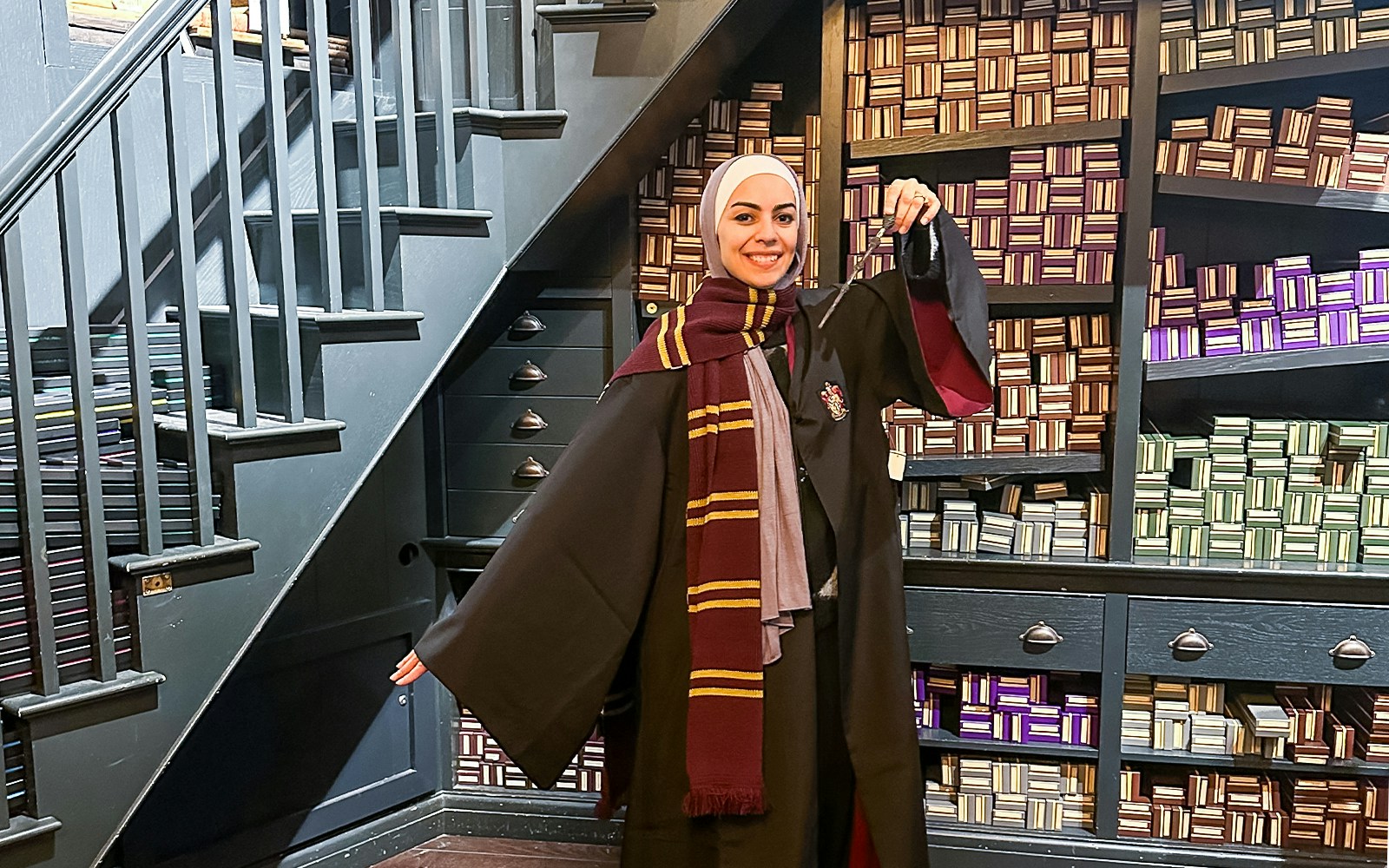 Visitor in Harry Potter attire exploring Diagon Alley set at Harry Potter London tour.