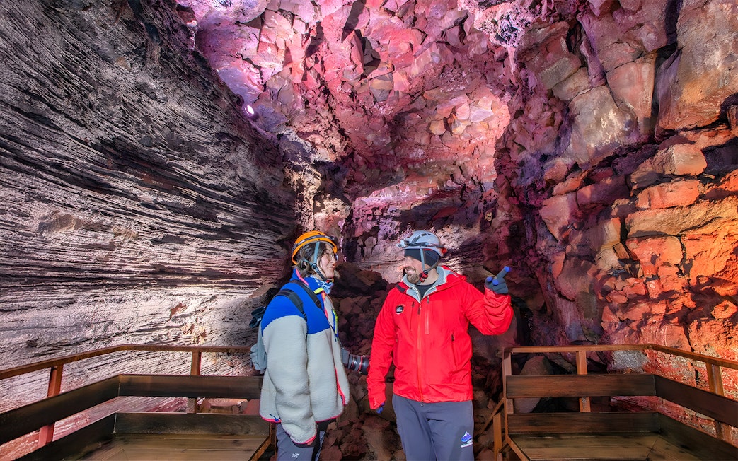 Tour guide and guest exploring Raufarhólshellir Lava Cave, Iceland.