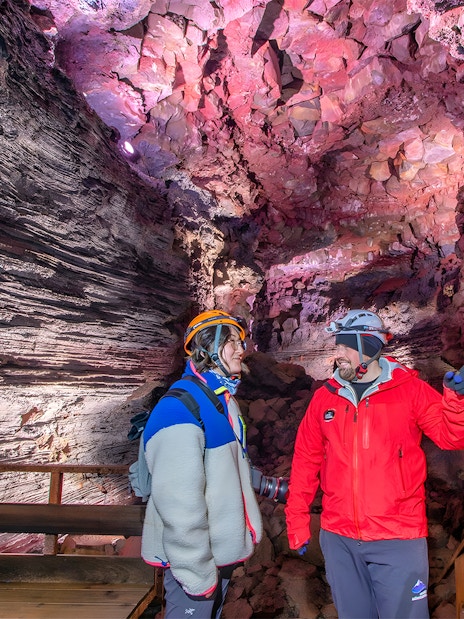 Tour guide and guest exploring Raufarhólshellir Lava Cave, Iceland.