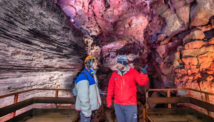 Tour guide and guest exploring Raufarhólshellir Lava Cave, Iceland.