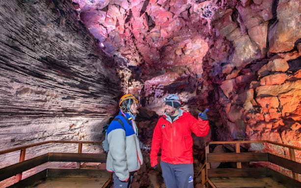 Tour guide and guest exploring Raufarhólshellir Lava Cave, Iceland.
