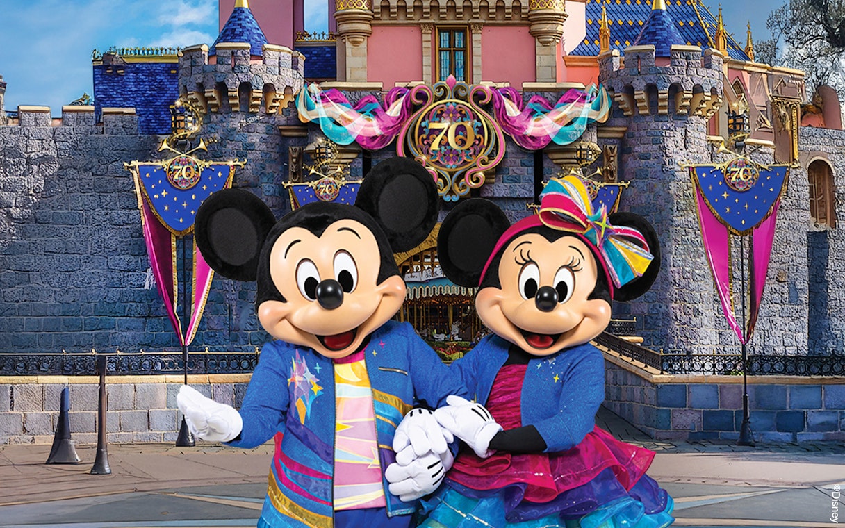 Mickey and Minnie Mouse in front of Sleeping Beauty Castle at Disneyland Park, California.