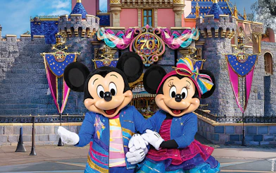 Mickey and Minnie Mouse in front of Sleeping Beauty Castle at Disneyland Park, California.