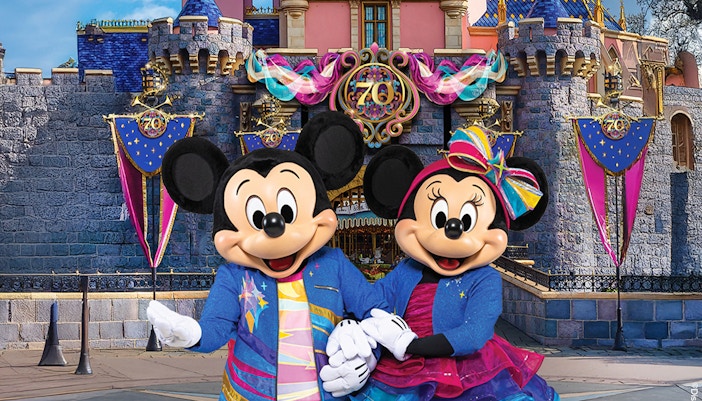 Mickey and Minnie Mouse in front of Sleeping Beauty Castle at Disneyland Park, California.