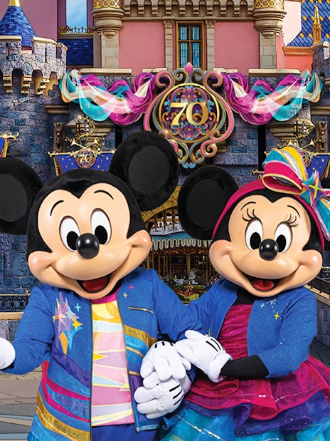 Mickey and Minnie Mouse in front of Sleeping Beauty Castle at Disneyland Park, California.