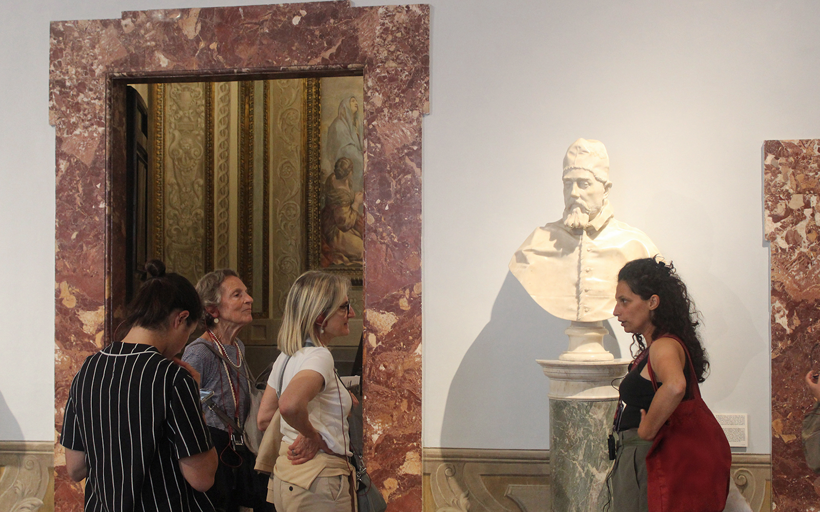 Tour guide explaining a sculpture to visitors inside Palazzo Barberini.