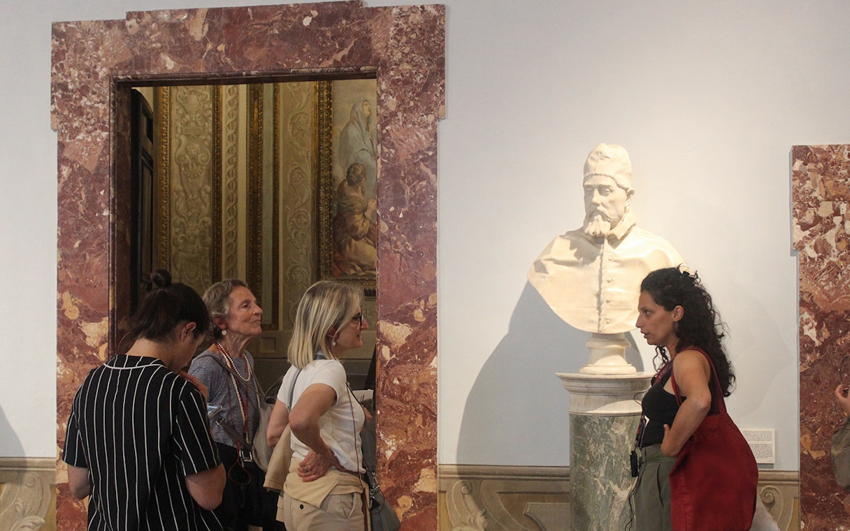 Tour guide explaining a sculpture to visitors inside Palazzo Barberini.