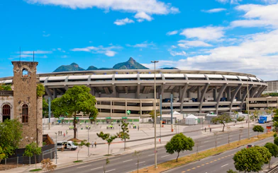 Maracanã Stadium in Rio de Janeiro with mountains in the background.