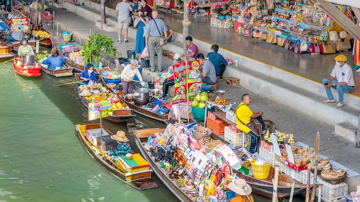 Damnoen Saduak Floating Market boats with goods, vibrant market scene, Thailand tour.