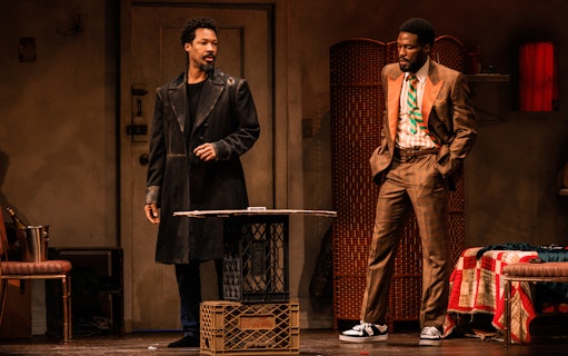 Two actors on stage in a scene from "Topdog/Underdog" play.