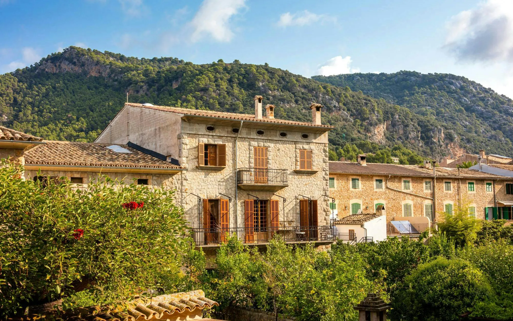 Traditional stone houses in Valldemossa village, Mallorca, Spain, with mountain backdrop.