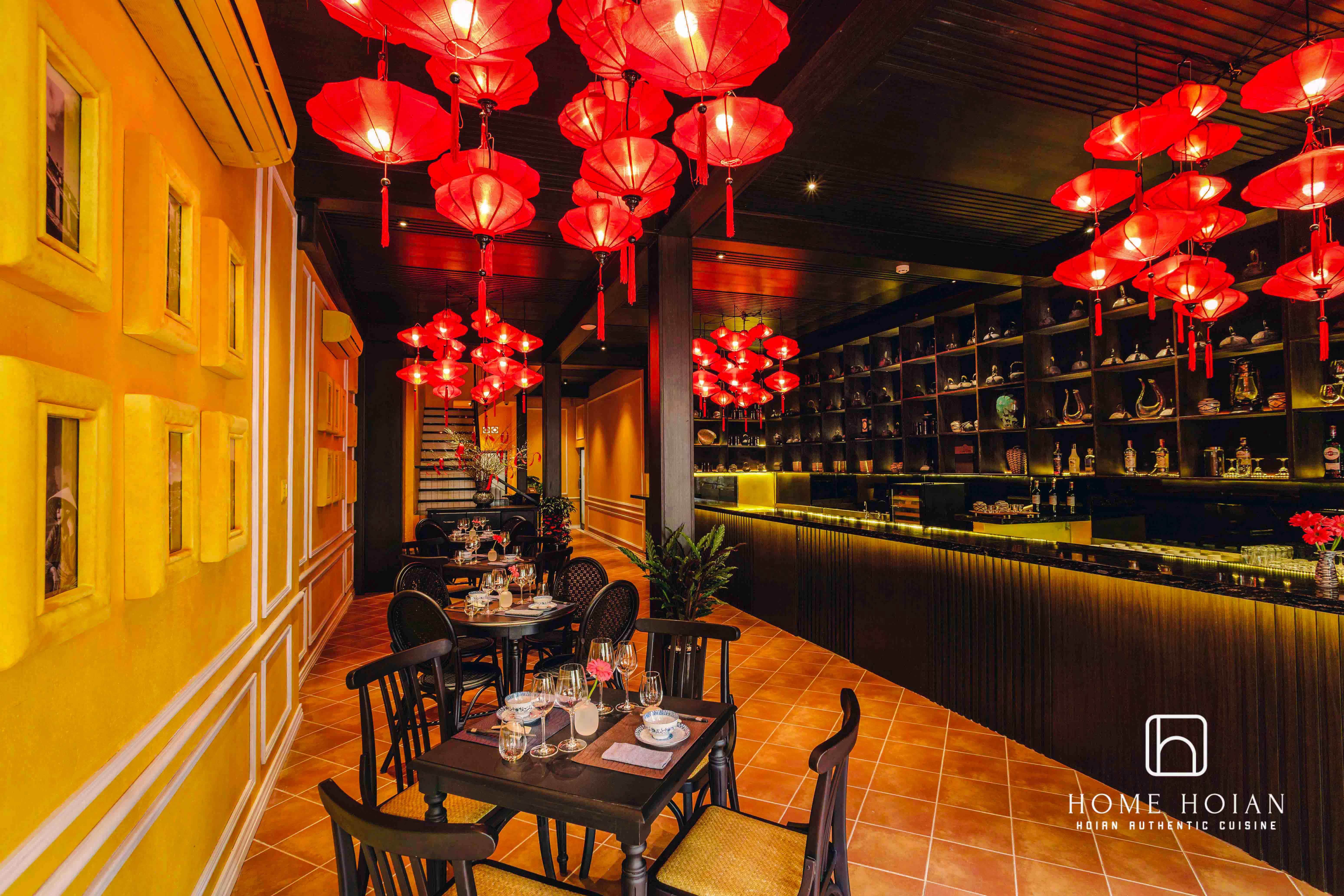 Dining area with red lanterns at HOME Hoi An Restaurant, offering all-you-can-eat Vietnamese cuisine.