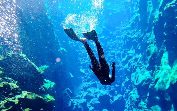 Snorkeler exploring the clear waters of Silfra fissure in Iceland.