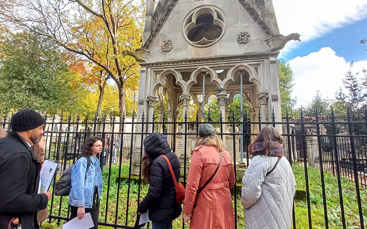 Visitors exploring a mausoleum at Père Lachaise Cemetery, France.